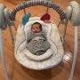 Cozy newborn in Ingenuity Soothe ‘n Delight swing with plush toys and soft padding for ultimate comfort