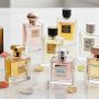 A collection of luxury designer perfume bottles arranged elegantly on a white marble surface in 2026