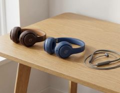 Three different models of Beats headphones arranged neatly on a modern wooden desk.