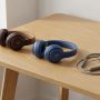 Three different models of Beats headphones arranged neatly on a modern wooden desk.