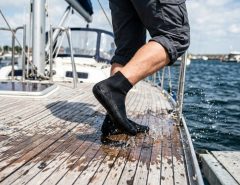 Pair of anti-slip water socks showcasing textured rubber sole grips on poolside tile.