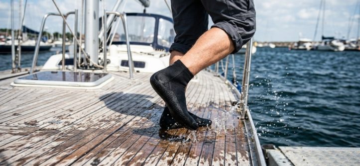 Pair of anti-slip water socks showcasing textured rubber sole grips on poolside tile.