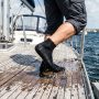 Pair of anti-slip water socks showcasing textured rubber sole grips on poolside tile.