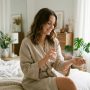 Woman spraying perfume on her wrist during her morning routine.