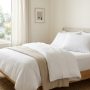 A clean cooling pillowcase resting on a neatly made bed.