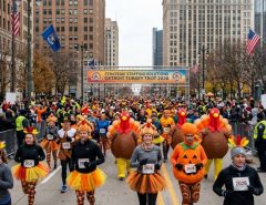 Runners and walkers in festive Thanksgiving costumes at the Strategic Staffing Solutions Turkey Trot 2026 in Downtown Detroit